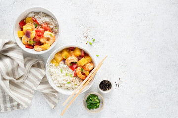 Rice with pineapple shrimp curry in bowl on concrete table, top view copy space