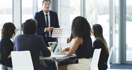 Giving them the facts. Cropped shot of a businessman using a digital tablet while giving a presentation to his colleagues in an office.