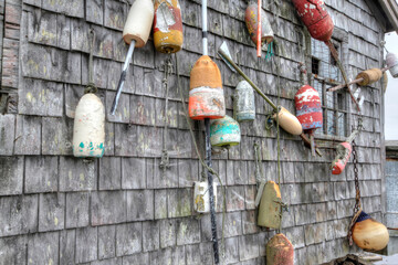 lobster buoys of various color on shack