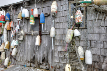 lobster buoys of various color on shack