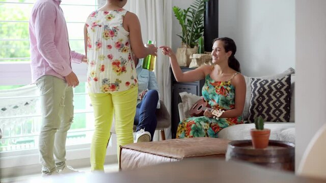 Woman Hosting Party Brings Bier Bottles To Friends And Toast Together. Dynamic Movement From Bottles In Close Up To Wide Shot.
