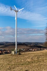 Small domestic wind turbine in the Czech countryside. Ecological energy. Wind turbine in the countryside. Green deal. Clean energy.