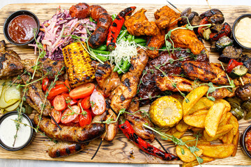 The mix of grilled meat and vegetables. Plate of mixed meat.