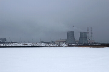 Obraz premium operating power plant in winter on the shore of the bay
