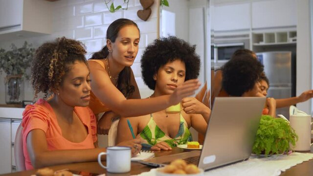 Woman explaining college subjects to female colleagues in laptop. Woman understand subject after help from friend.
