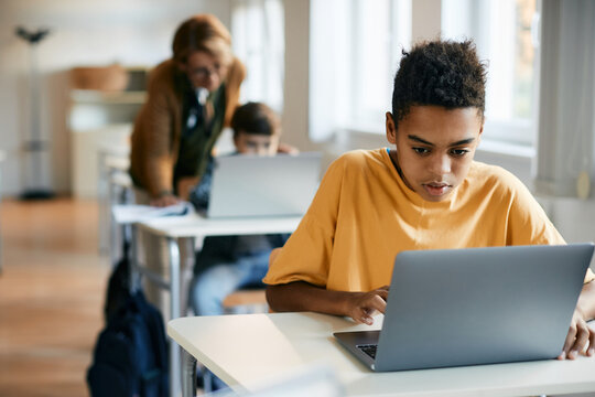 Black schoolboy uses laptop during computer science class at elementary school.