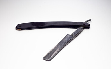 An old straight razor on white isolate.Folding sharp razor.