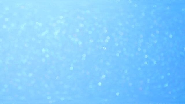 Sparkling blue background material. Blur and bokeh. The festive texture shimmers in the light.