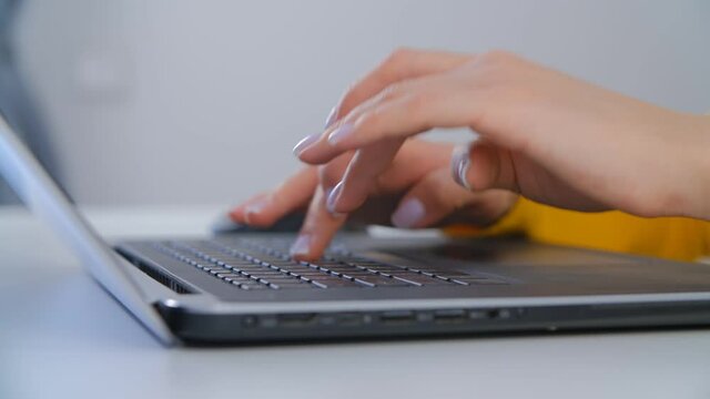 Freelancer woman typing on keyboard. Young adult female working on laptop computer in office. Professional person doing work on modern notebook pc in closeup 4k video