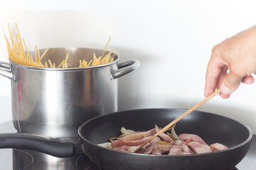 Man cooking spaghetti with bacon