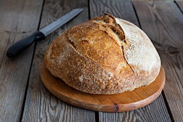 Fresh crispy homemade bread with whole grain flour sourdough(unleavened) on a wooden background.