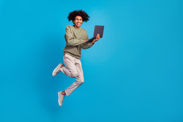 Full body profile side photo of young man jump use laptop manager agent workshop energetic isolated over blue color background