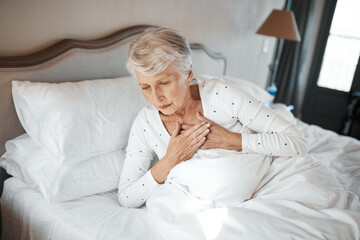 No one is immune. Shot of a senior woman experiencing chest pain in bed in a nursing home.