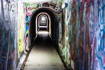 Fototapeta na wymiar Tunnel, Unterführung, Gehweg, Angst, Depression, Licht am Ende, eng, Beklemmung, Graffiti, Beton