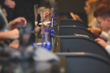 Process of checking in on a conference congress forum event, registration desk table, visitors and attendees receiving a name badge and entrance wristband bracelet and register electronic ticket,