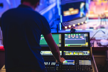View of lighting technician operator working on mixing console workplace during live event concert on stage show broadcast, light mixer controller panel, sound technician with professional equipment - obrazy, fototapety, plakaty