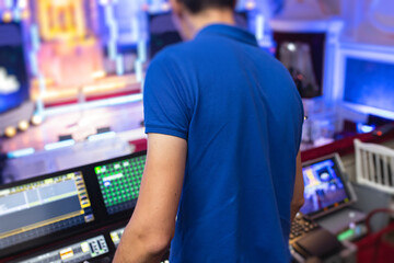 View of lighting technician operator working on mixing console workplace during live event concert...