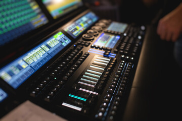 View of lighting technician operator working on mixing console workplace during live event concert...