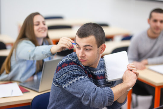 Students teasing each other having fun during class in a modern classroom..