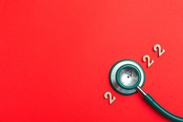 Fototapeta na wymiar Stethoscope number 2022 on red background creative idea new trend medical banner calendar cover closeup with copy space