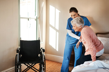 Simple movements aren't so simple anymore. Shot of a young nurse helping a senior woman get up from...