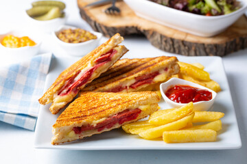 Turkish toast, mixed toast with cheddar cheese, sausage and ham, with fried potatoes (Turkish name; Karisik tost)