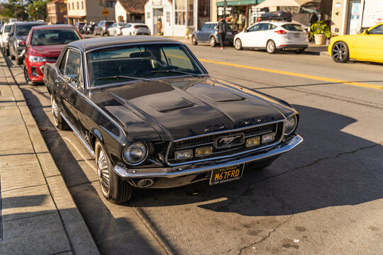 Black old Ford Mustang parked on the street. 