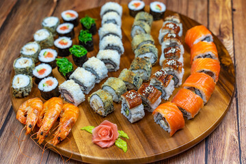 Assortment of rolls and sushi on a wooden board.