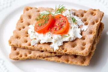 Fresh rye crispbread with cream cheese and vegetables isolated on white