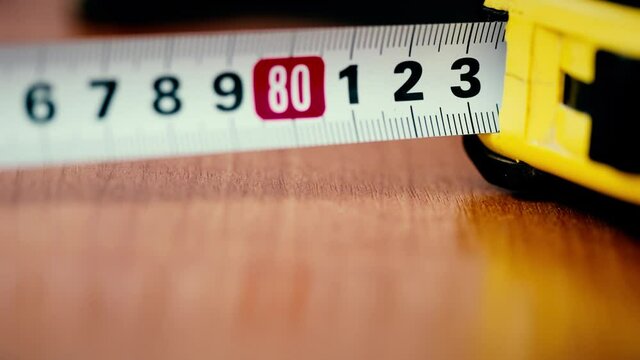 Yellow tape measure, roll of measuring tape.