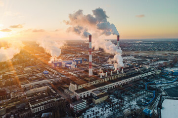 Factory smokestack emissions at sunrise, climate change and global warming for the environment. Aerial view