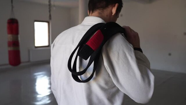 brazilian jiu jitsu bjj black belt male athlete holding belt at gym training sport self defence concept