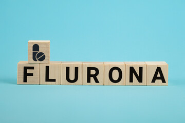 Covid-19 corona and the symbol flu flurona. Wooden cube concept word flurona on blue background....