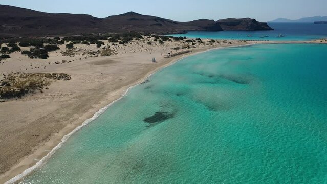 Aerial drone video of paradise turquoise sandy beach and bay of Simos in island of Elafonisos visited by yachts and sail boats, South Peloponnese, Lakonia, Greece