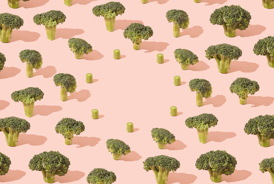 Various broccoli flowers pattern on a pastel pink background. Climate change minimal concept.