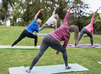 Multiracial people doing yoga exercise at city park