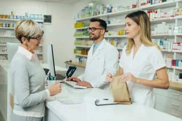 Foto op Plexiglas Two pharmacist giving prescription medications to senior female customer in a pharmacy © Zamrznuti tonovi
