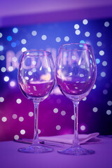 Empty wine glass with purple bokeh.