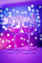 Empty wine glass with purple bokeh.