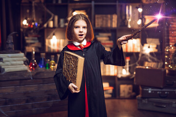 little witch makes a spell with a magic wand. Halloween party. Cosplay. Happy childhood