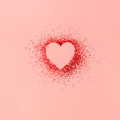 Creative composition of heart shape in red shiny glitter on pastel pink background. Minimal Valentine's day, mother's day or birthday concept. Top view. Pink or red aesthetic.