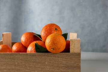 Tangerines in wooden box on wood background.