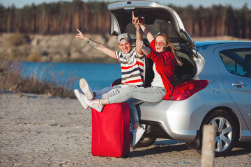 Happy couple traveling together. Man and woman having fun in the trip. Car sharing for young people.