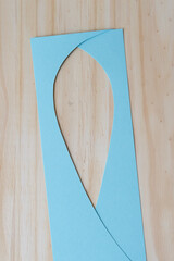 two pieces of blue paper overlapping on a wood surface