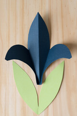 paper fleur-de-lis or fleur-de-lys shape with leaves on a wooden surface