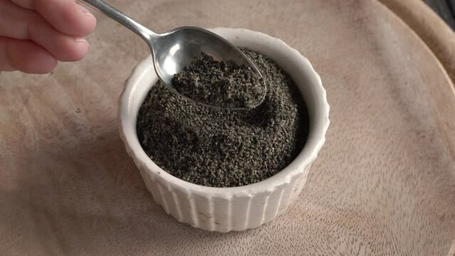 Taking ripe nettle seeds with a spoon, close up