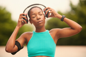 Woman in sports clothing and headphones with eyes closed - obrazy, fototapety, plakaty