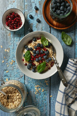 Yogurt with oatmeal, served with blueberries and pomegranate seeds. Flat lay.