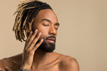 Studio shot of young man with dreadlocks with closed eyes