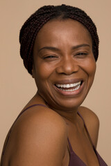Studio portrait of mature woman with braided hair laughing © Cultura Creative